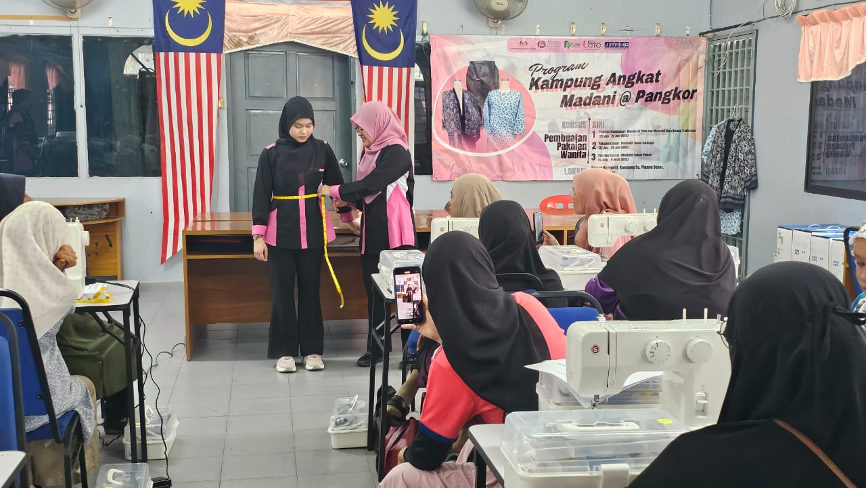 Cik Senijulita menunjukkan kaedah pengukuran badan kepada peserta