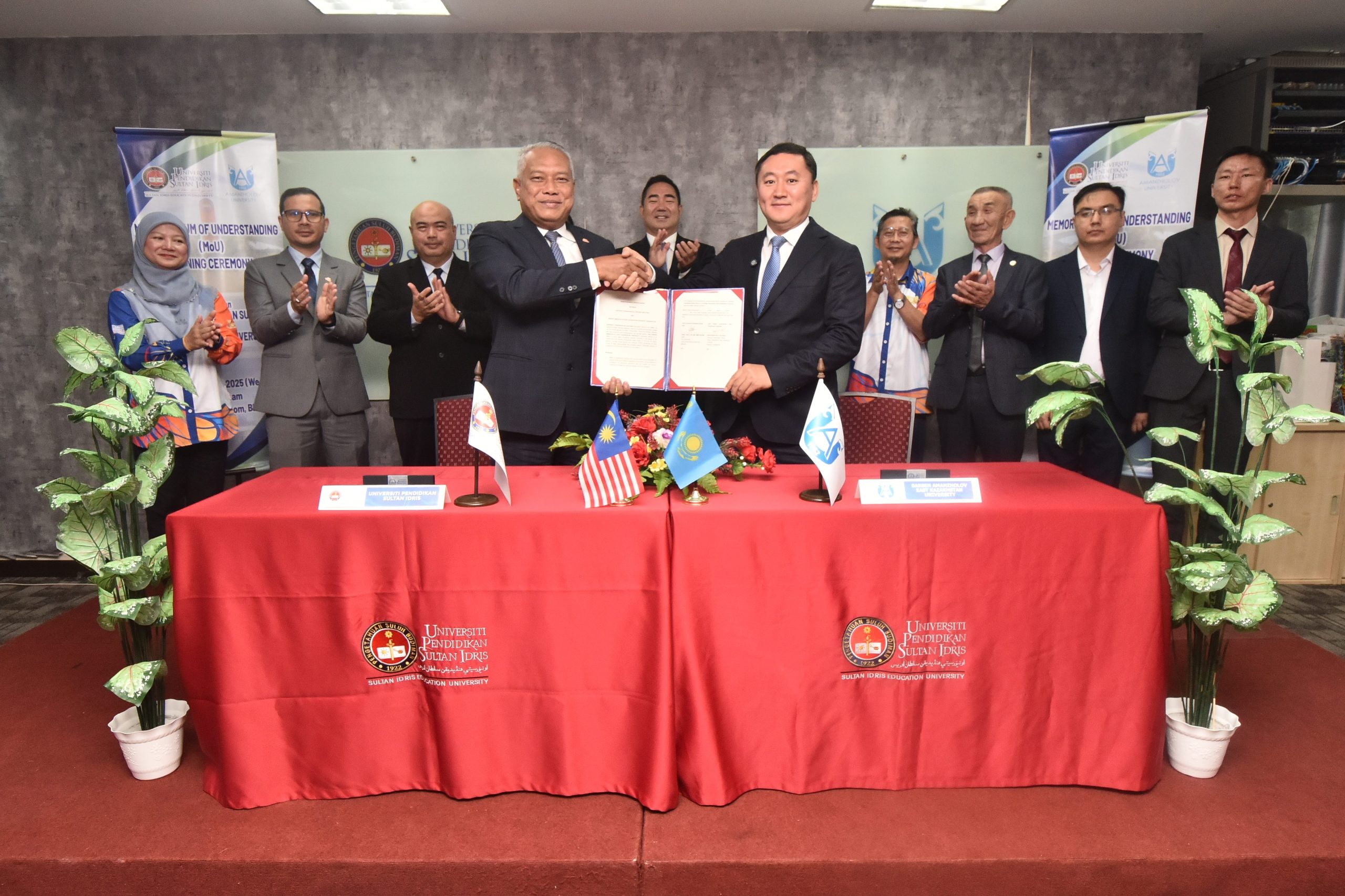 Dr. Md Amin (kiri) berjabat tangan bersama Mukhtar Tolegen sambil memegang dokumen MoU yang ditandatangani bersama dalam satu majlis yang diadakan di Bilik Seminar, Fakulti Sains dan Matematik, Kampus Sultan Azlan Shah UPSI.