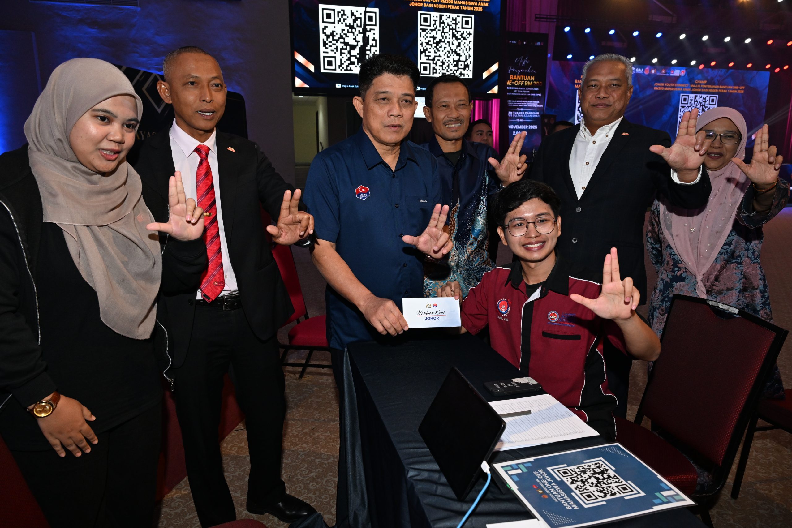 Mohd Yusla (tiga dari kiri) ketika menyerahkan Bantuan One-Off RM200 kepada salah seorang mahasiswa UPSI pada Majlis Penyerahan Bantuan Mahasiswa Anak Johor 2025 Zon Perak di Dewan Tuanku Canselor, Kampus Sultan Azlan Shah UPSI.