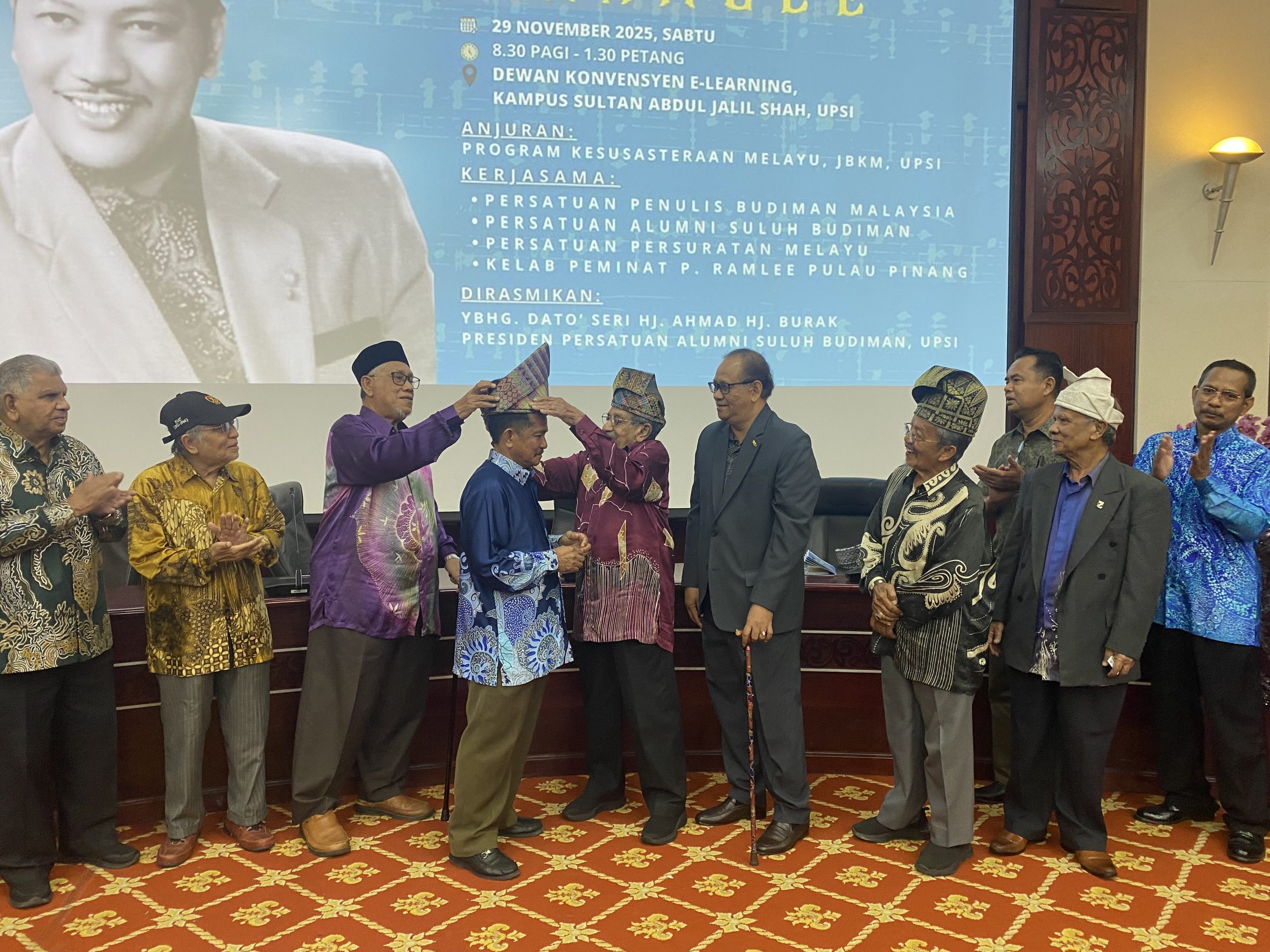 Mohd Yussof (lima dari kiri) menyarungkan tengkolok kepada Ahmad (empat dari kiri) sebagai tanda menyempurnakan gimik perasmian Seminar Pemikiran P. Ramlee di Dewan Konvensyen E-Learning, Kampus Sultan Abdul Jalil Shah, UPSI