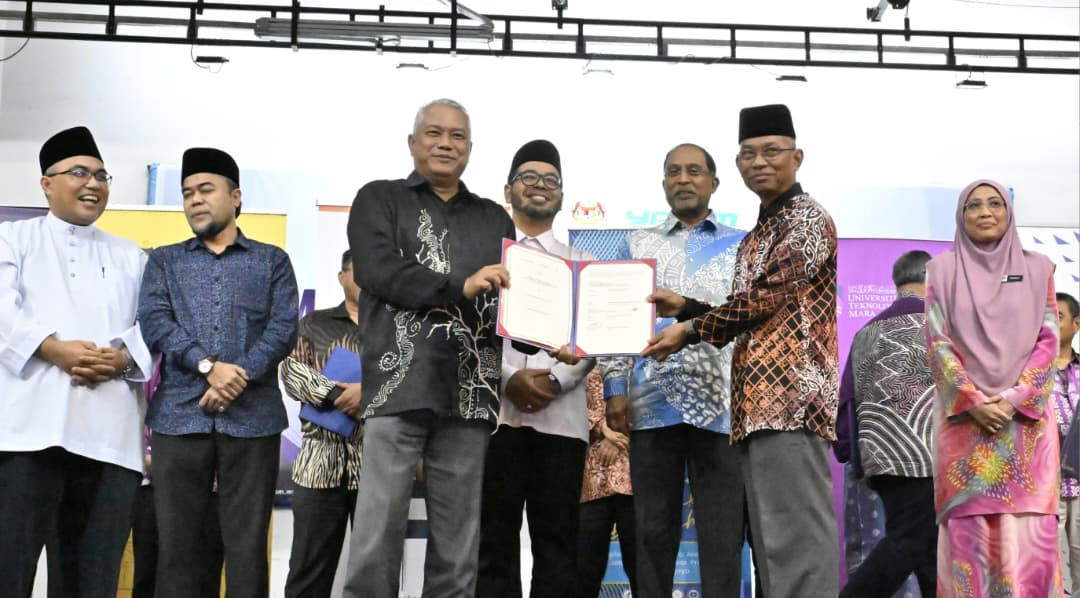 Md Amin (hadapan, kiri) menunjukkan dokumen MoU yang telah ditandatanganinya bersama Dr Hasan pada Majlis Menandatangani Memorandum Persefahaman antara YADIM dan Institusi Pengajian Tinggi Awam dan Swasta di Masjid Wilayah Persekutuan Kuala Lumpur