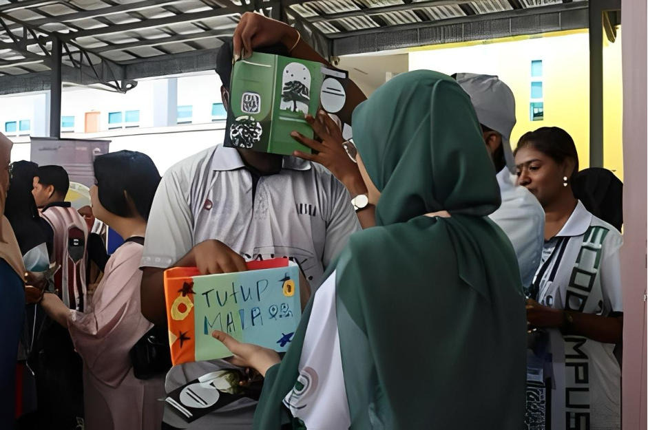 Salah seorang pengunjung menerima ganjaran setelah berjaya menjawab kuiz. Gambar oleh: Raxielly Janson