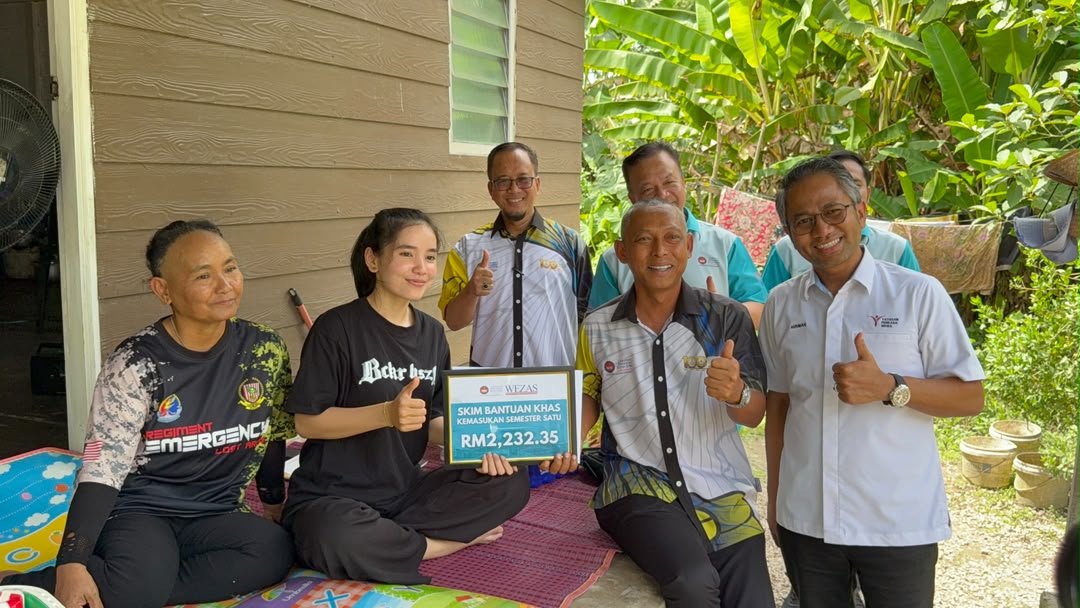 Hirman (kanan) bersama Norkhalid (dua dari kanan) ketika menyampaikan Skim Bantuan Khas Kemasukan Semester Satu kepada Lovely Sabana pada kunjungan Ziarah Prihatin UPSI bersama KPT di Tumpat, hari ini.